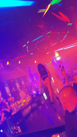 Nightclub scene with dancing, neon lights, and bar crowd
