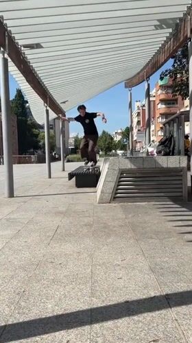 Skateboarder performs bench tricks in Terrassa park