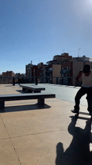Skateboarder practices tricks on concrete benches in Spanish plaza