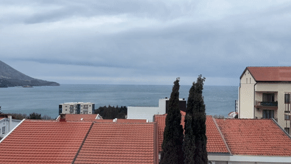 Overcast ocean view captured above residential rooftops in Montenegro