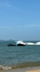 Jet skis, speedboats, and beachgoers fill a sunny Ko Samui morning
