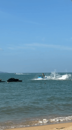Jet skis, speedboats, and beachgoers fill a sunny Ko Samui morning