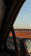 Driver crosses orange-railed bridge in Belgrade under blue skies