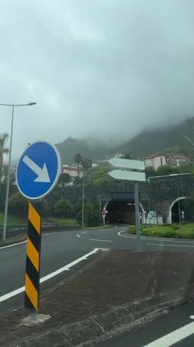 Car approaches tunnel in Faial, Madeira on cloudy afternoon
