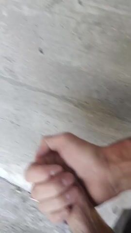 The video shows a person's hands and forearms against a gray, textured surface, likely concrete or a similar material. The individual's skin appears to have some discoloration or redness on the wrist. The hands are in motion, with one hand appearing to grasp the other. The lighting is somewhat dim, and the focus is on the hands.
