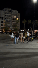 Circle dancing at night in Vlorë's lit outdoor streets
