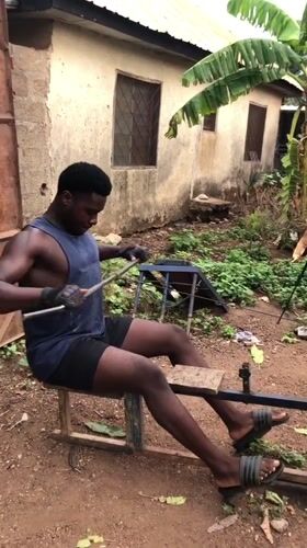 Man exercises on homemade rowing machine in Akwanga