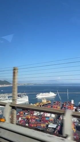 Clear skies over busy Salerno port captured from moving vehicle