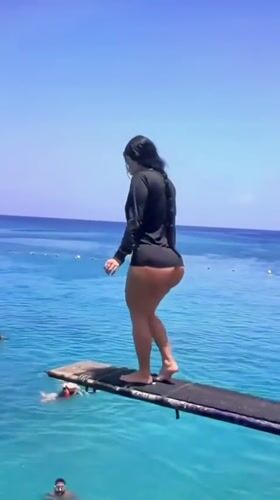Poised on a diving board over clear blue water in Gyhum