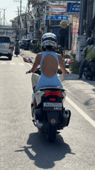 Woman commutes by scooter through Dalung streets