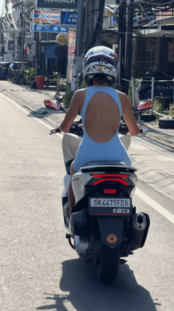 Woman commutes by scooter through Dalung streets
