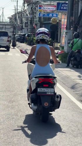 Woman commutes by scooter through Dalung streets