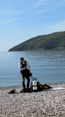 Diver prepares gear on Montenegro beach during morning hours
