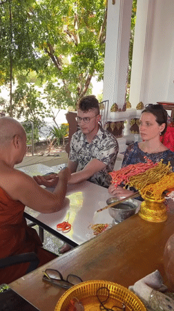 Buddhist monk blesses tourists at Thai temple