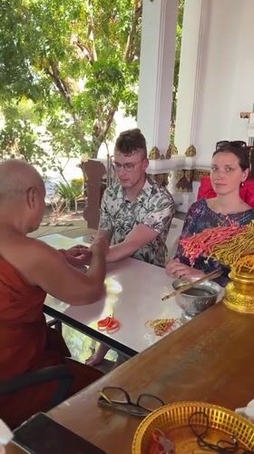 Buddhist monk blesses tourists at Thai temple