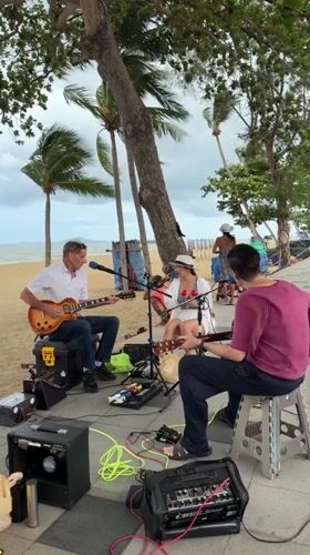 Street Musicians Perform on Pattaya Beach Promenade Under Overcast Skies