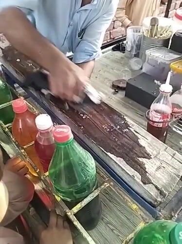 Street vendor serves shaved ice treats to children in Pakistan