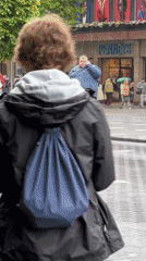 Man takes phone call on wet city crosswalk