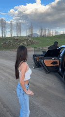 Young people gather around BMW on rural road in Armenia