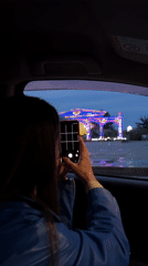 Tourist photographs illuminated star archway in Birobidzhan from car
