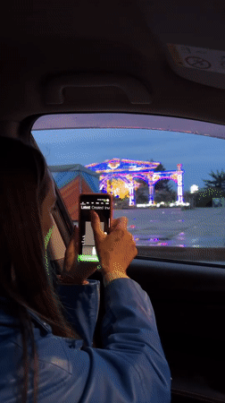 Tourist photographs illuminated star archway in Birobidzhan from car