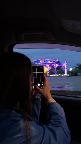 Tourist photographs illuminated star archway in Birobidzhan from car