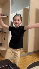 Young girl poses with extended arms in Sarapul room