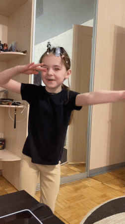 Young girl poses with extended arms in Sarapul room