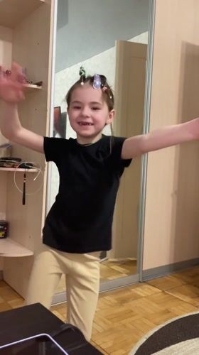 Young girl poses with extended arms in Sarapul room