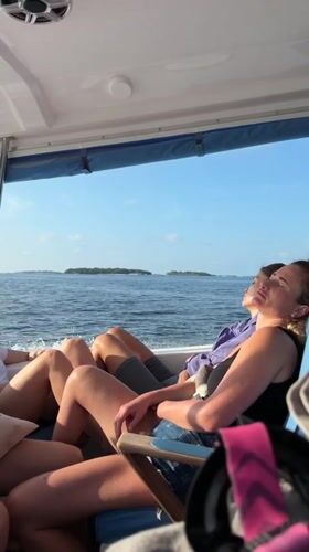 Tourists relax on boat journey near Maafushi, Maldives