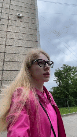 Woman in pink jacket filmed, photographed outdoors in Izhevsk