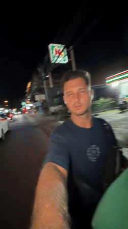 Tourist films selfie video while riding scooter in Kuta