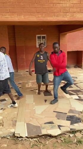 Four men gather at covered outdoor space in Vom