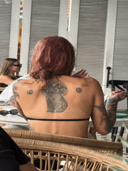Pink-haired patron enjoys early morning cafe visit in Kuta