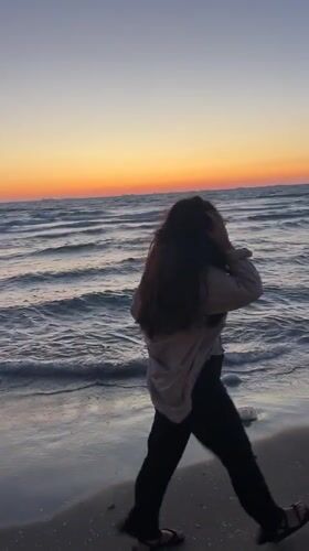 Woman encounters jellyfish during sunset beach walk in Kiryat Yam