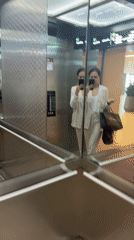 Woman takes elevator selfie with luxury shopping bag in Dubai