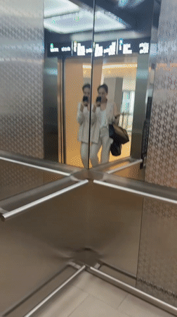 Woman takes elevator selfie with luxury shopping bag in Dubai