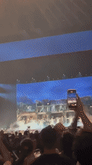 Concert features performer in ballet costume with animated cityscape screens