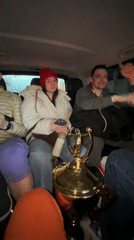Group celebrates with gold trophy in Moscow car