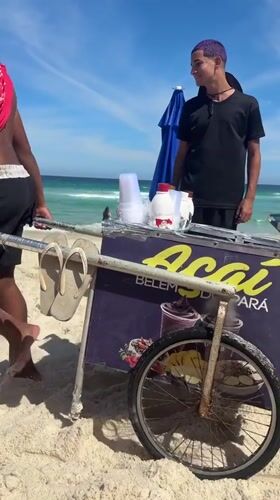 Two men spotted walking on Rio beach during sunny afternoon