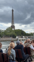 Tour guide addresses passengers on Seine River boat near Eiffel Tower