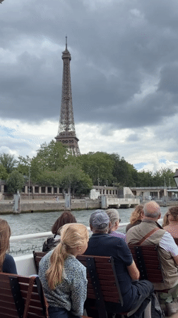 Tour guide addresses passengers on Seine River boat near Eiffel Tower