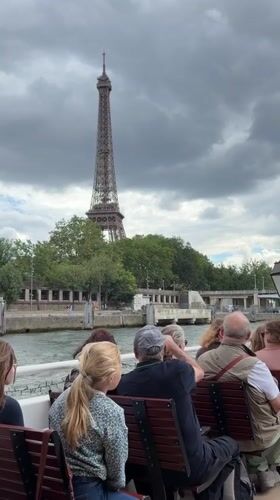 Tour guide addresses passengers on Seine River boat near Eiffel Tower