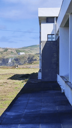 Waterfall observed near modern building in Ribeira Grande, Portugal