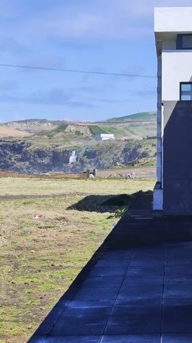 Waterfall observed near modern building in Ribeira Grande, Portugal