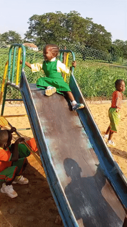Kids at play on a colorful schoolyard playground in Akwanga