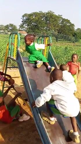 Kids at play on a colorful schoolyard playground in Akwanga