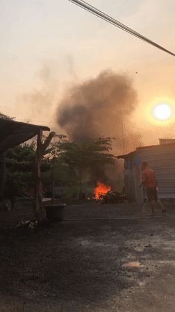 Street market morning in East Java, with a fire in the background