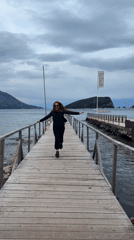 Woman and dog run together on Budva pier