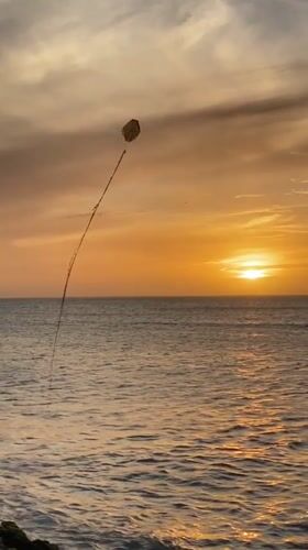 Evening kite flying captured at Juan Griego waterfront sunset